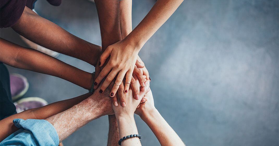 team huddle with all hands in