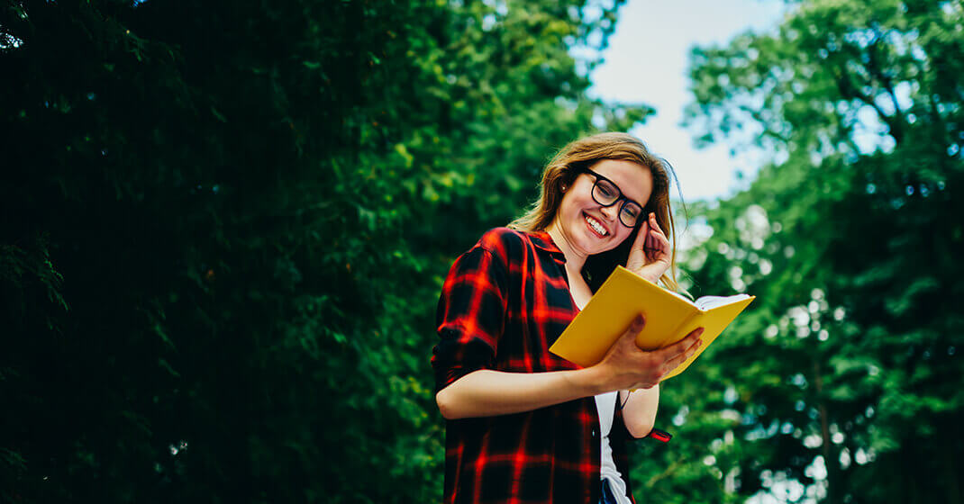 woman looking at notebook smiling