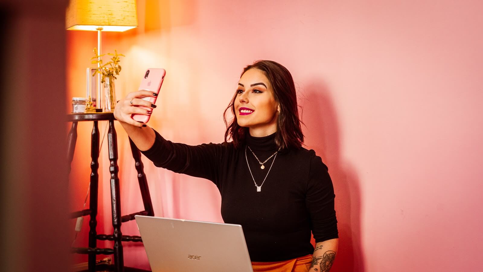 woman taking a selfie holding a laptop